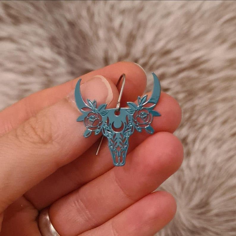 Little Miss floral filigree steer skull earrings.