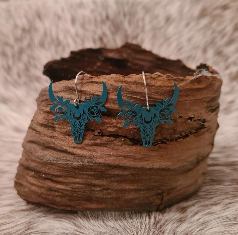 Little Miss floral filigree steer skull earrings.