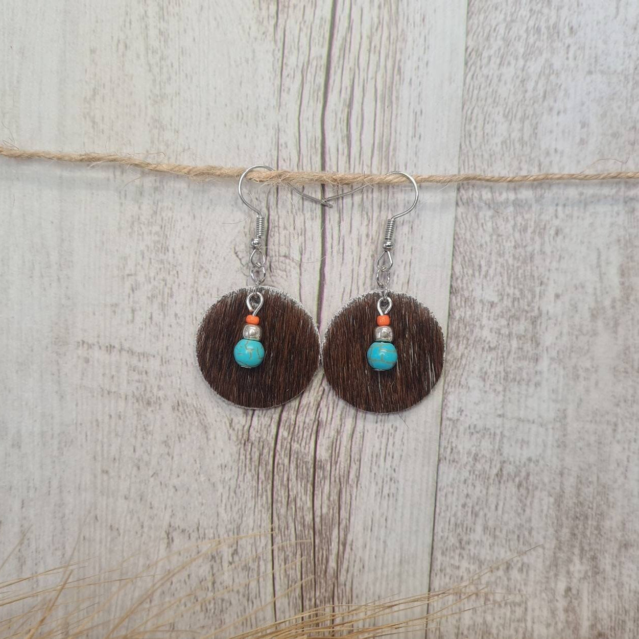 High Noon genuine cowhide earrings with natural turquoise bead detail.